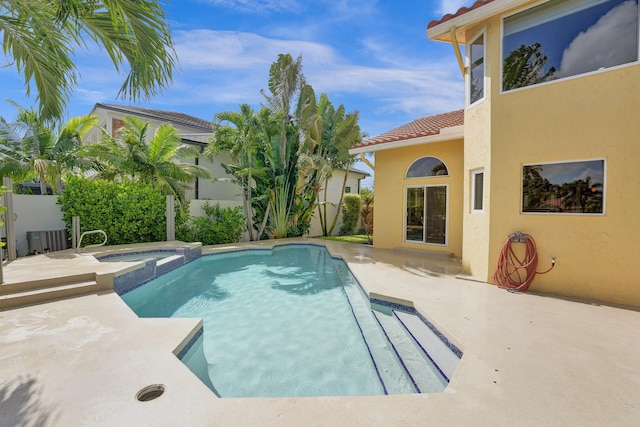 view of swimming pool featuring an in ground hot tub and a patio