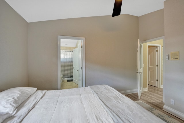 bedroom with lofted ceiling, ceiling fan, light hardwood / wood-style floors, and ensuite bath