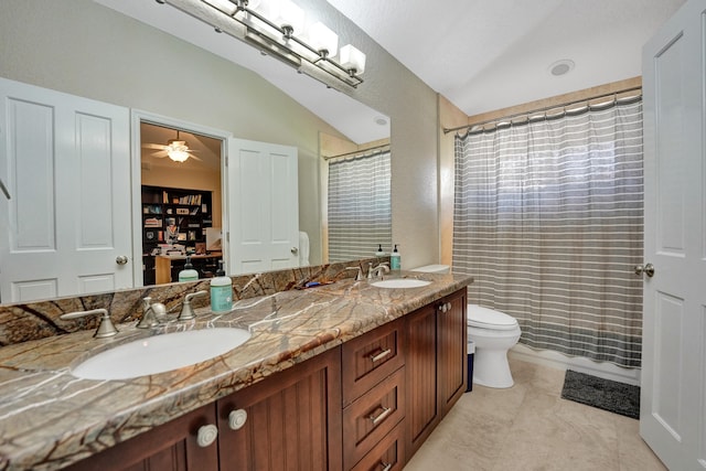 bathroom with toilet, tile patterned flooring, vanity, ceiling fan, and vaulted ceiling