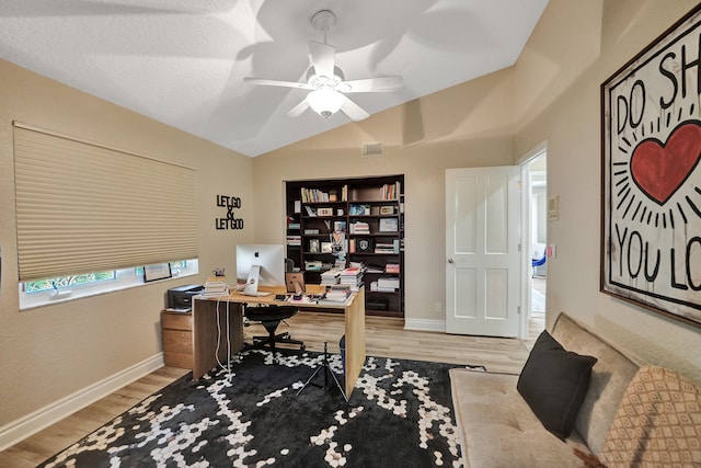 home office with lofted ceiling, ceiling fan, light wood-type flooring, and a textured ceiling