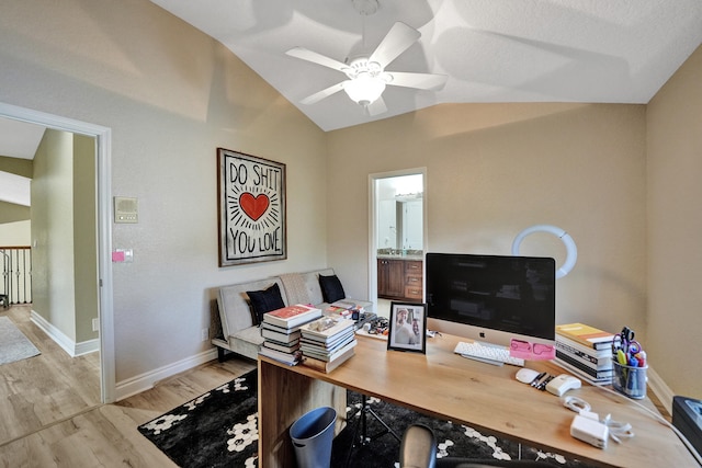 office with light wood-type flooring, ceiling fan, vaulted ceiling, and a textured ceiling