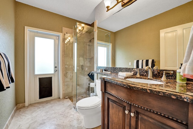 bathroom with a shower with shower door, toilet, a textured ceiling, and vanity