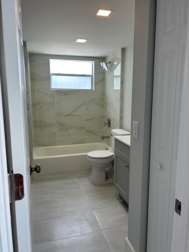 full bathroom featuring tiled shower / bath combo, vanity, and toilet