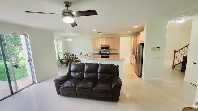 living room with light tile patterned floors, sink, and ceiling fan