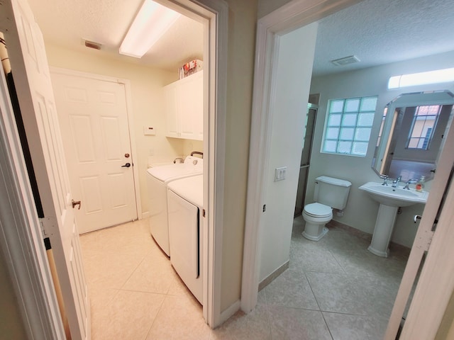 interior space featuring cabinets, light tile patterned flooring, and a textured ceiling