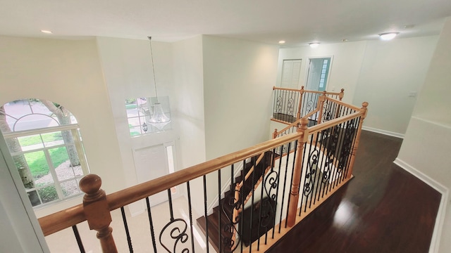 corridor with a chandelier and dark hardwood / wood-style floors