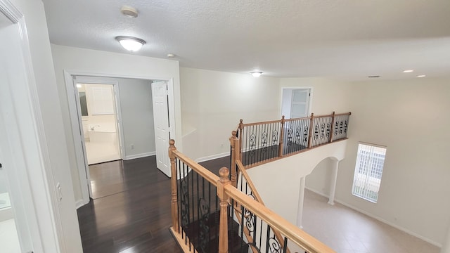 hallway featuring a textured ceiling and dark hardwood / wood-style flooring