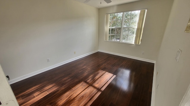 spare room with ceiling fan and dark wood-type flooring