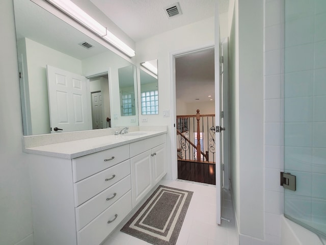 bathroom with a textured ceiling, vanity, and tile patterned floors