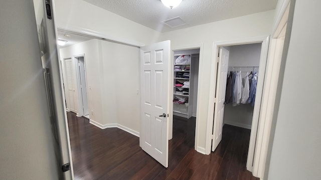 hallway featuring a textured ceiling and dark wood-type flooring