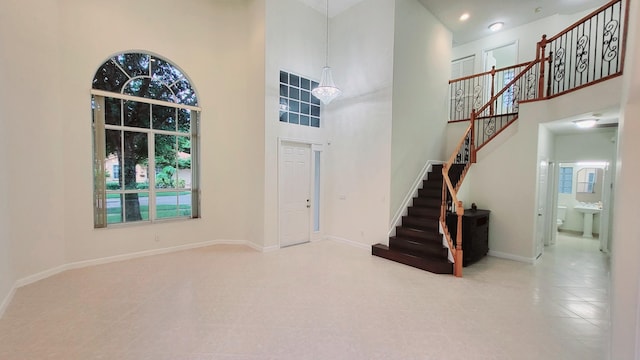 entrance foyer with an inviting chandelier and a towering ceiling