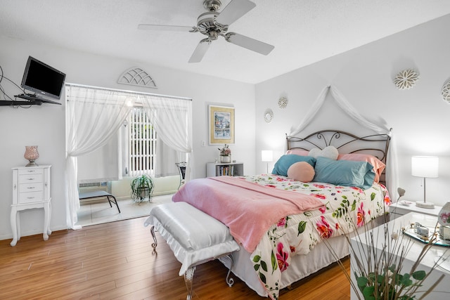 bedroom with a textured ceiling, hardwood / wood-style floors, and ceiling fan