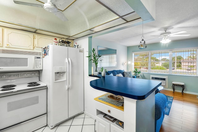 kitchen with a textured ceiling, white appliances, light hardwood / wood-style flooring, kitchen peninsula, and ceiling fan