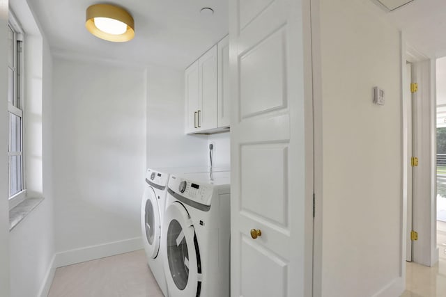 washroom with washer and dryer and cabinets