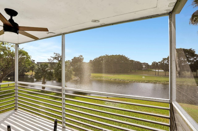 unfurnished sunroom featuring a water view, ceiling fan, and a healthy amount of sunlight