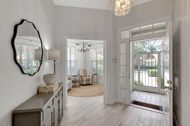 doorway with a chandelier and light hardwood / wood-style flooring