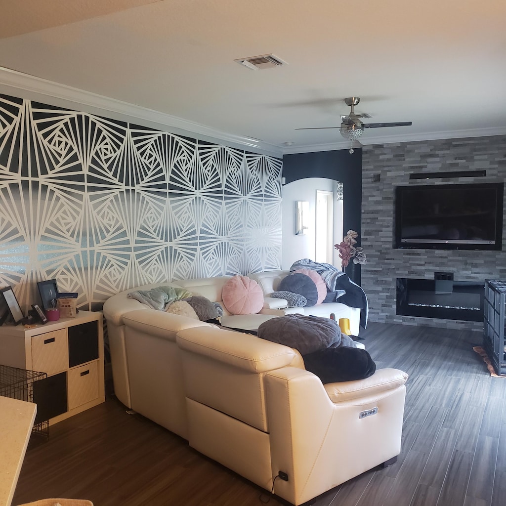 living area featuring crown molding, dark wood-style floors, and a ceiling fan