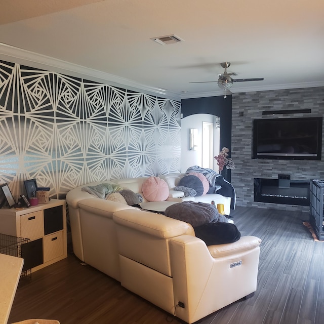 living area featuring crown molding, dark wood-style floors, and a ceiling fan