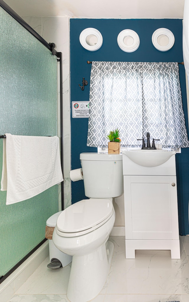 bathroom featuring vanity, toilet, and a shower with shower door