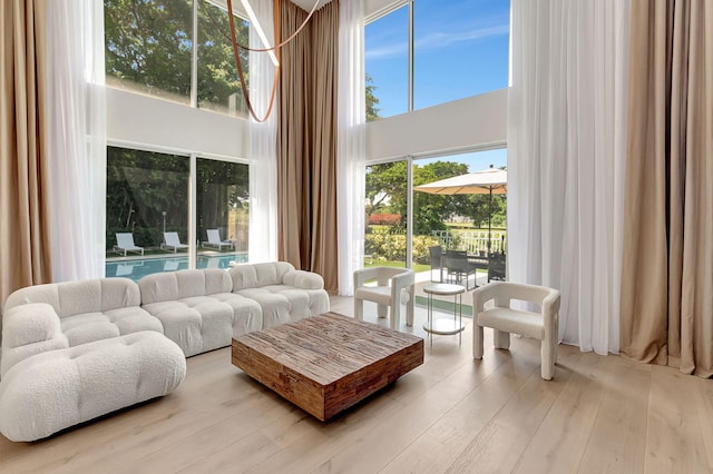 living room featuring a high ceiling and light hardwood / wood-style floors