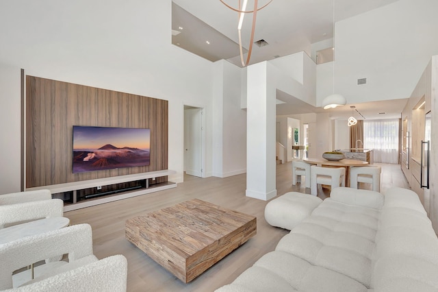 living room with light hardwood / wood-style flooring and a high ceiling