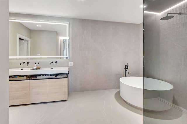 bathroom with tile walls, separate shower and tub, and vanity