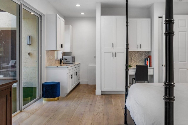 bathroom with vanity, hardwood / wood-style flooring, and tasteful backsplash