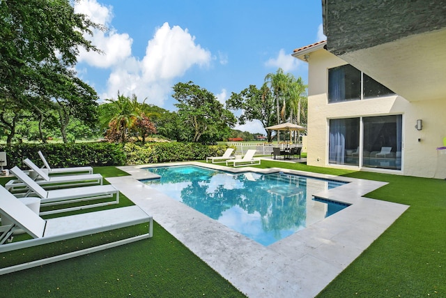 view of pool with a lawn and a patio area