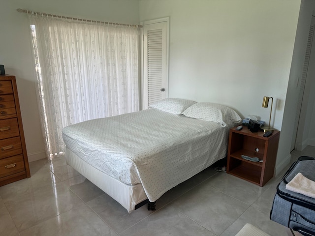 bedroom with multiple windows and light tile patterned floors