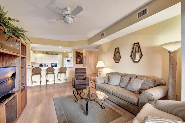 living room with ceiling fan and light hardwood / wood-style floors