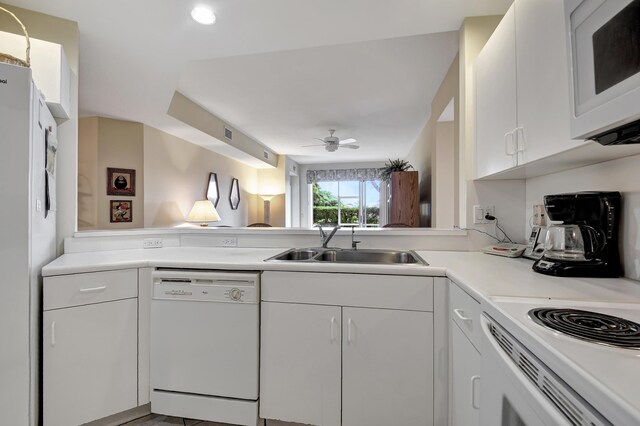 kitchen with white cabinets, white appliances, sink, kitchen peninsula, and ceiling fan