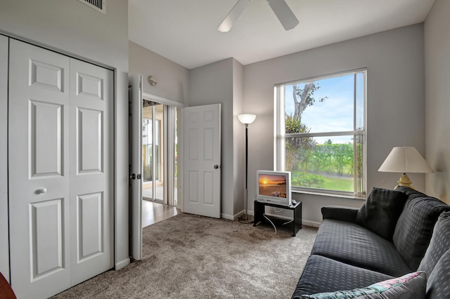 living area with ceiling fan and light carpet