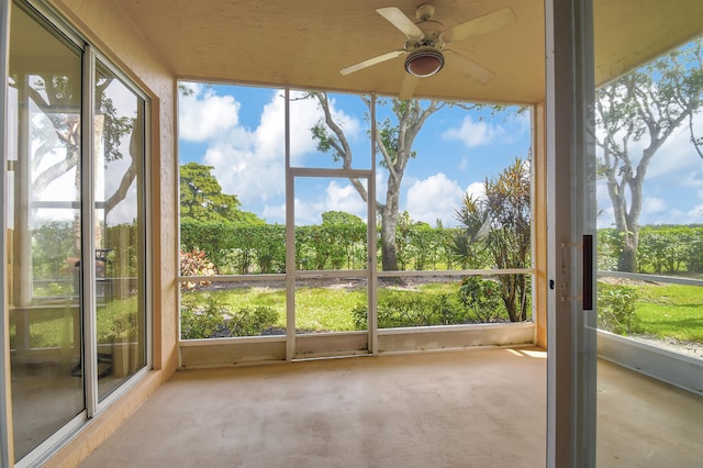 unfurnished sunroom featuring ceiling fan and plenty of natural light