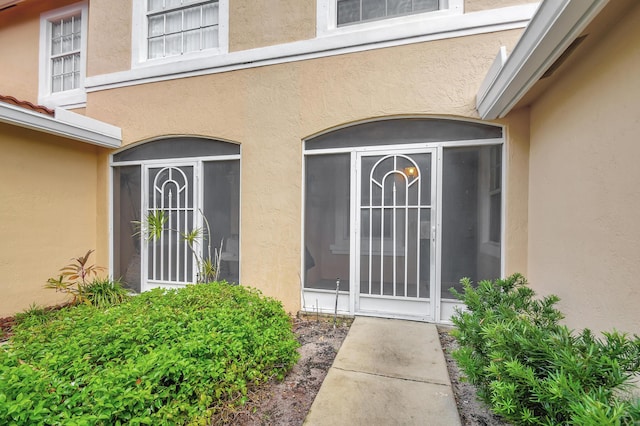 doorway to property featuring stucco siding