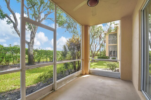 unfurnished sunroom with ceiling fan