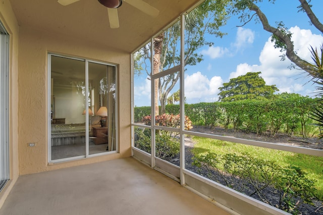 unfurnished sunroom with ceiling fan