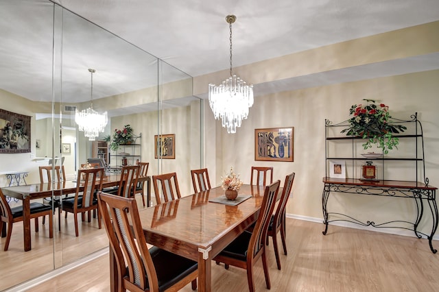 dining space featuring light hardwood / wood-style flooring and a chandelier