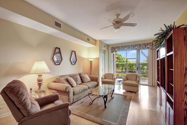 living room with wood-type flooring and ceiling fan