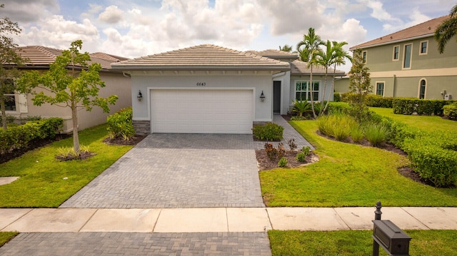 mediterranean / spanish house with a garage and a front lawn