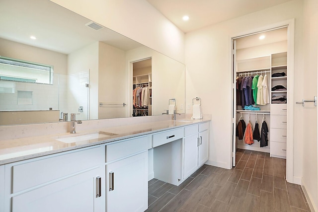 bathroom with walk in shower and vanity