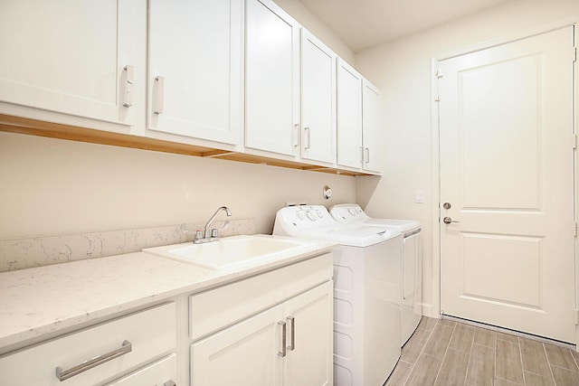 laundry area featuring cabinets, sink, and separate washer and dryer