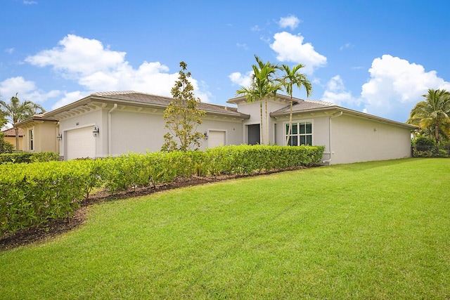 view of front of home with a front lawn and a garage