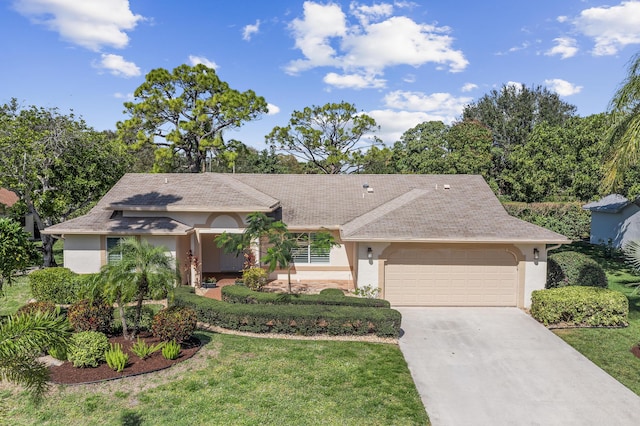 view of front facade with an attached garage, a front yard, concrete driveway, and stucco siding