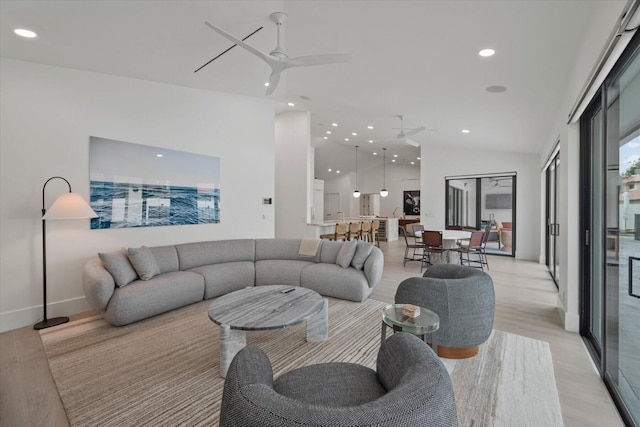 living room with light wood-type flooring, lofted ceiling, and ceiling fan