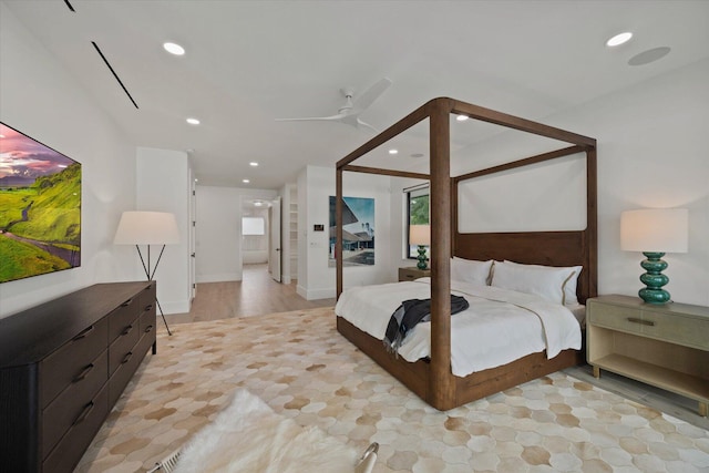 bedroom featuring ceiling fan, light wood-type flooring, and multiple windows