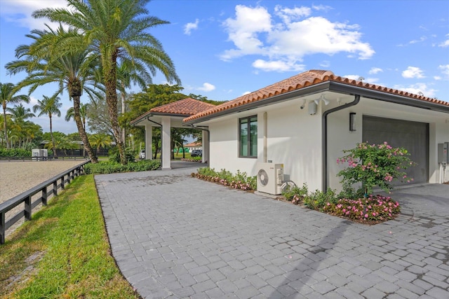 view of property exterior with ac unit and a garage