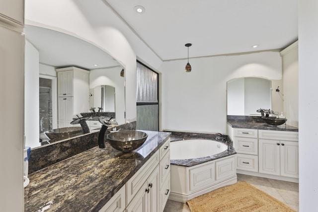 bathroom featuring tile patterned floors, a bathing tub, and vanity