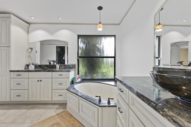 bathroom featuring vanity, tile patterned floors, and a tub