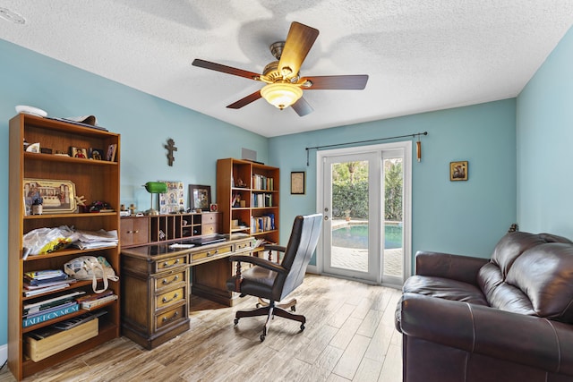 home office with ceiling fan, a textured ceiling, and light wood-type flooring