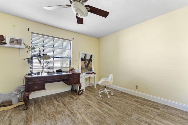 office with ceiling fan, light wood-type flooring, and a textured ceiling